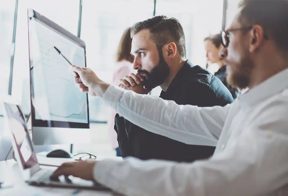 Two quality managers easily accessing quality data on a computer through AI enabled detection signals